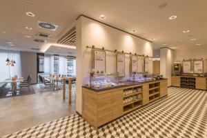 a restaurant with a counter with mirrors and tables at Holiday Inn Express - Wuppertal - Hauptbahnhof, an IHG Hotel in Wuppertal