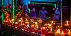 uma mesa com velas, flores vermelhas e pessoas em Biplan City em Daugavpils