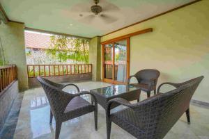 a patio with a table and chairs on a balcony at The Grand Bali Nusa Dua in Nusa Dua