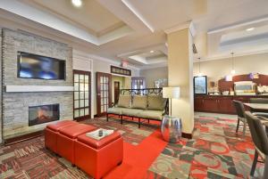 a living room with a couch and a fireplace at Holiday Inn Express & Suites Utica, an IHG Hotel in Utica