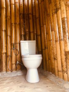 a toilet in front of a bamboo wall at Green Hill Restaurant & Cottages in San Vicente