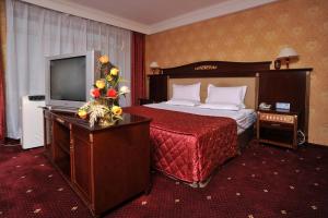 a hotel room with a bed and a television at White House Hotel in Ulaanbaatar +85 photos