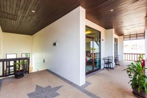 a room with a white wall and a table and chairs at Monaburi Boutique Resort in Rawai Beach