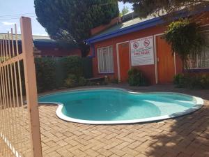 una pequeña piscina frente a una casa en Garden View Lodge en Mafikeng
