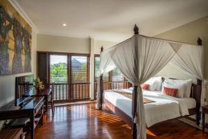 a bedroom with a canopy bed and a balcony at Villa Saffron Seminyak Bali in Seminyak +13 photos