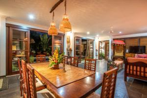 uma sala de jantar com uma mesa de madeira e cadeiras em Villa Saffron Seminyak Bali em Seminyak