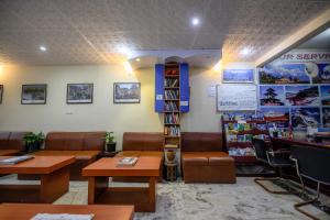 une salle d'attente avec des chaises, des tables et une étagère à livres dans l'établissement Hotel Pomelo House, à Katmandou