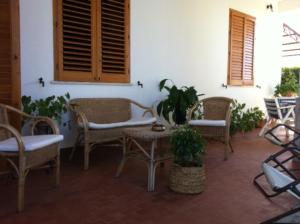 スコペッロにあるResidenza Biancaの籐の椅子と植物のあるテーブル付きのパティオ