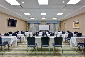 a conference room with tables and chairs and a screen at Holiday Inn Express & Suites Ottawa West - Nepean by IHG in Ottawa +32 photos