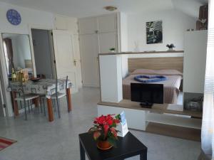 un soggiorno con letto e tavolo con TV di Sun & Sol a Caleta De Fuste