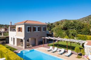 a villa with a swimming pool and a house at Villa Evanthia in Melidhónion
