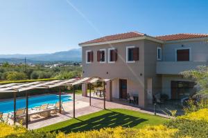 a villa with a swimming pool and a house at Villa Evanthia in Melidhónion