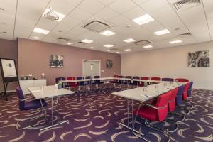 ein Konferenzraum mit Tischen und roten Stühlen in der Unterkunft Holiday Inn Express Preston South, an IHG Hotel in Preston