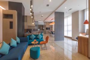 uma sala de estar com um sofá azul e uma mesa em Holiday Inn Express - Xichang City Center, an IHG Hotel em Xichang