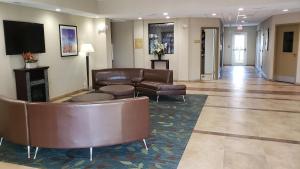 vestíbulo con muebles de cuero y TV de pantalla plana en Candlewood Suites Woodward, an IHG Hotel en Woodward