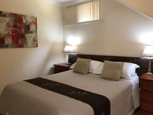 a bedroom with a bed with two night stands and two lamps at Alfred Cove Short Stay in Perth