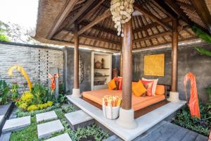 an outdoor bedroom with an orange bed in a pavilion at Villa Saffron Seminyak Bali in Seminyak