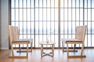 due sedie e un tavolo davanti ad una grande finestra di 谷町君Hotel Crush On 京都四条烏丸 a Kyoto