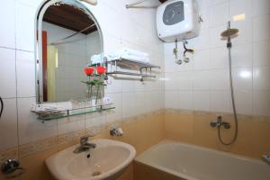 un bagno con un lavandino, una vasca e uno specchio di ATS Hotel a Hanoi