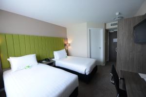 a hotel room with two beds and a flat screen tv at Holiday Inn Wolverhampton - Racecourse by IHG in Wolverhampton