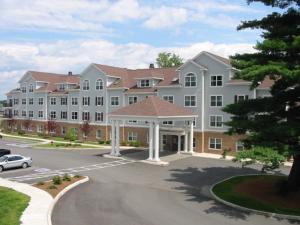 a large white building with a parking lot at Holiday Inn Express Hotel & Suites White River Junction by IHG in White River Junction