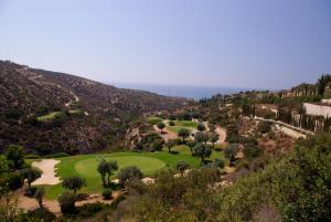 vistas a un campo de golf en las montañas en 1 bedroom Apartment Nesoi with sea and golf views, Aphrodite Hills Resort, en Kouklia