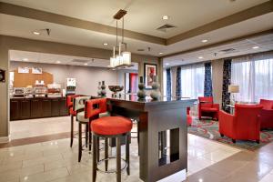a kitchen and living room with a bar and red chairs at Holiday Inn Express Hurricane Mills Waverly, an IHG Hotel in Hurricane Mills