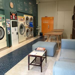a laundry room with washing machines and a table at guest house Sora in Osaka