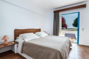 a bedroom with a bed and a view of the ocean at Olympia Mare in Kardamaina