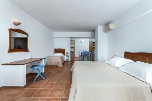 a bedroom with a bed, chair, and a desk at Olympia Mare in Kardamaina