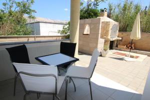 a patio with a table and chairs and a fireplace at Apartment Doder in Pag