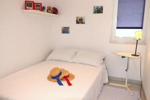 a small bedroom with a bed with a hat on it at Apartment Doder in Pag