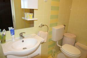 a bathroom with a sink and a toilet at Apartment Doder in Pag +10 photos