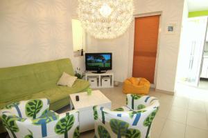 a living room with a couch and a tv at Apartment Doder in Pag
