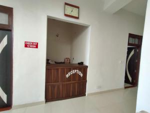 una habitación con un reloj en una pared blanca en ARJUN GUEST HOUSE, en Pathankot