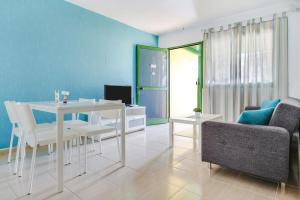 un soggiorno con tavolo e sedie bianchi di 8211 Bungalow Costa Calma Wifi a Costa Calma