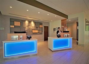 a woman standing in a lobby with blue lights at Holiday Inn Express & Suites Ocala, an IHG Hotel in Ocala