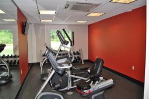 een fitnessruimte met cardio-apparatuur in een kamer met rode muren bij Holiday Inn Express Salem, an IHG Hotel in Salem