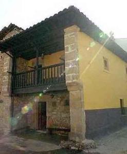 a building with a balcony on the side of it at Casa Rural Moradiellos in Arenas de Cabrales