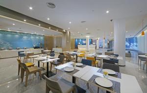 a restaurant with tables and chairs in a room at Holiday Inn Express - Xiamen City Center, an IHG Hotel in Xiamen