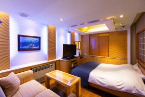 um quarto de hotel com uma cama e um sofá em WATER HOTEL Cy (Audlt Only) em Machida