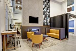 a lobby with a desk and chairs and a television at Holiday Inn Express Whitby Oshawa, an IHG Hotel in Whitby