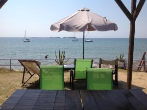 a table and chairs with an umbrella on the beach at Kefalonia Beach Hotel & Bungalows in Lixouri