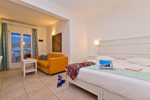 a hotel room with a bed with a laptop on a table at Yiannaki Hotel in Ornos