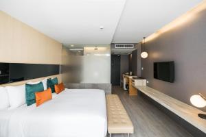 a bedroom with a large bed and a tv at Hotel Vista in Pattaya Central