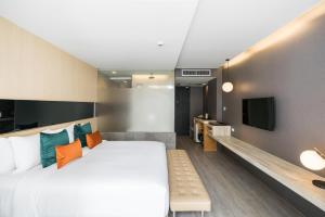 a bedroom with a large bed and a tv at Hotel Vista in Pattaya