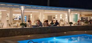 a group of people sitting at a restaurant at night at Yiannaki Hotel in Ornos