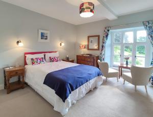 1 dormitorio con 1 cama, 2 sillas y ventana en Eastwrey Barton Country House, en Lustleigh
