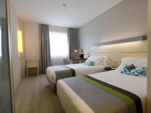 um quarto de hotel com duas camas e uma janela em Holiday Inn Express Pamplona, an IHG Hotel em Mutilva Baja