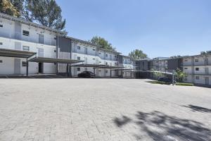 an empty parking lot in front of a building at The Residency Hurlingham in Johannesburg